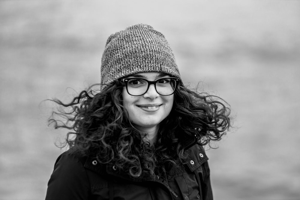 grayscale photo of woman wearing knit cap and eyeglasses