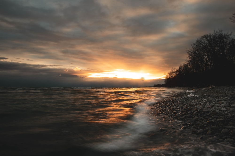 body of water during sunset