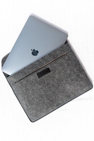 silver macbook on gray textile
