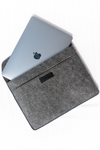 silver macbook on gray textile