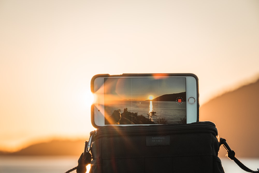 person taking photo of sunset