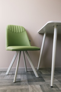 white and green chair beside white wall