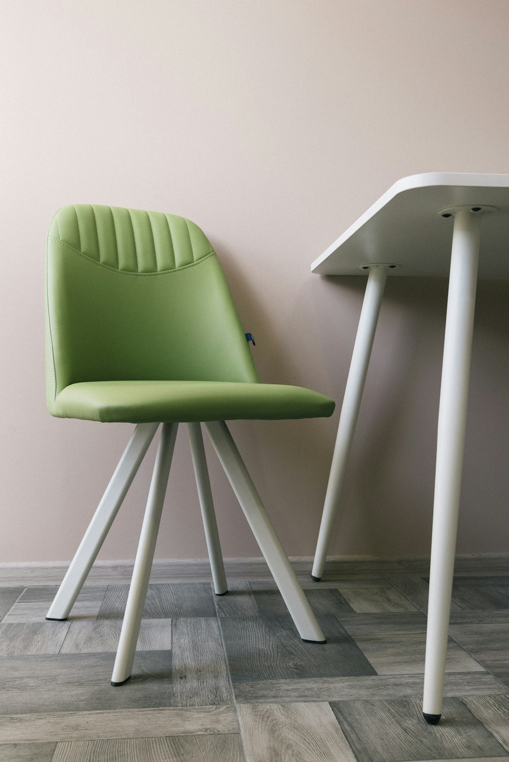 흰 벽 옆에 있는 흰색과 녹색 의자