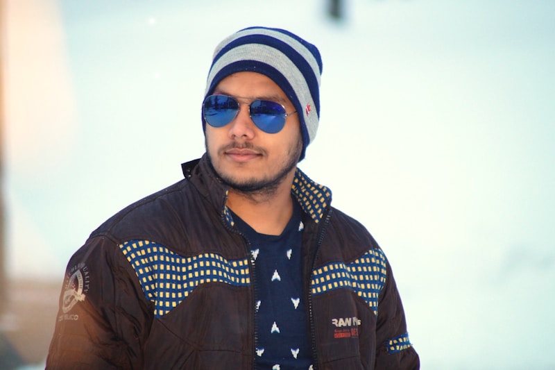 man in black jacket wearing blue and white knit cap