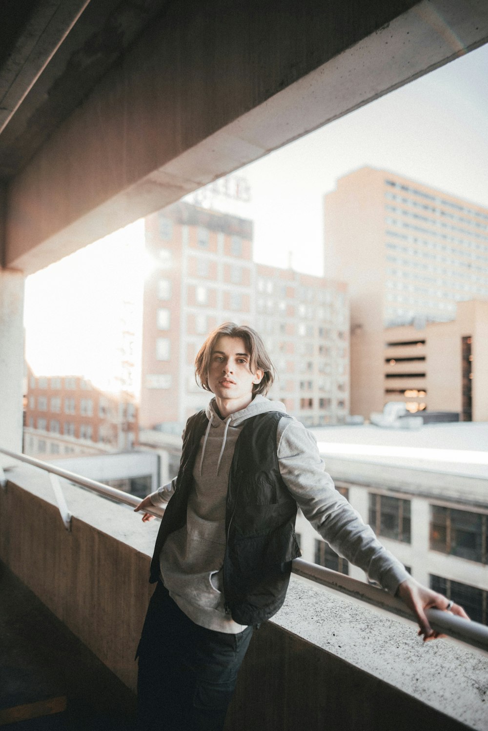 woman in black leather jacket standing beside brown wooden railings during daytime