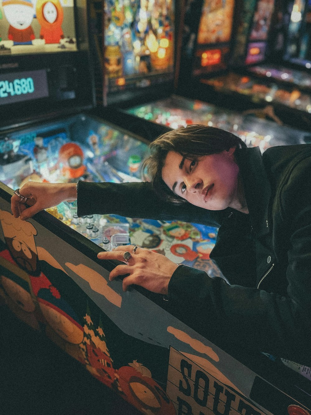 boy in black jacket playing arcade game