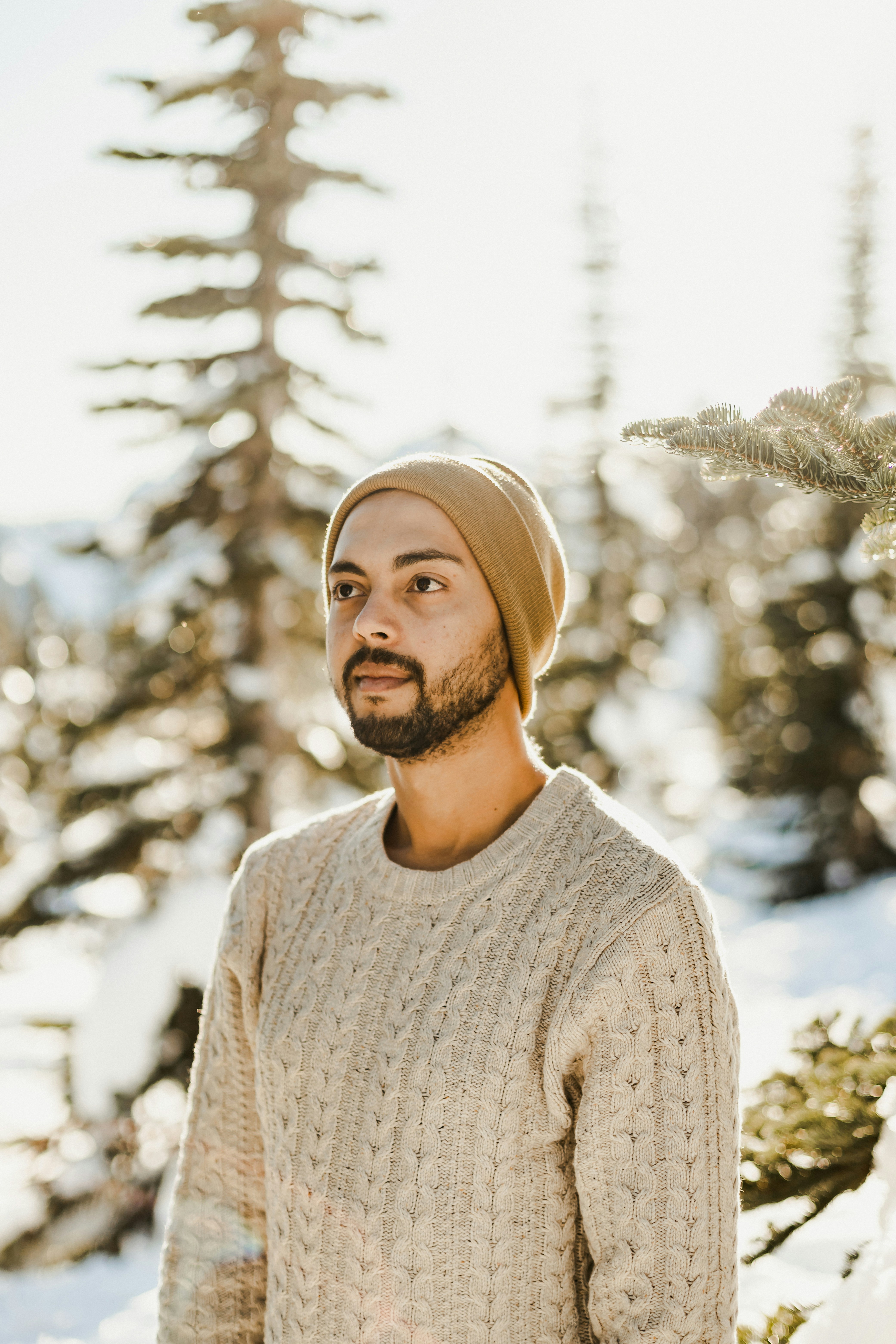 homme en pull en tricot gris et bonnet en tricot marron