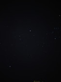 A dark, star-studded night sky filled with small, distant stars. The vastness and mystery of space are evident, with pinpricks of light scattered across the darkness.