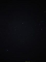 A dark, star-studded night sky filled with small, distant stars. The vastness and mystery of space are evident, with pinpricks of light scattered across the darkness.