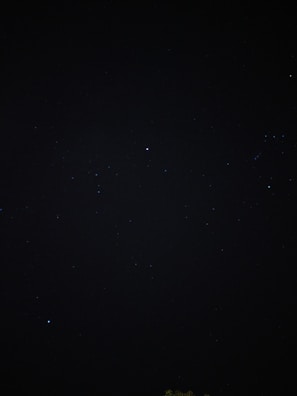 A dark, star-studded night sky filled with small, distant stars. The vastness and mystery of space are evident, with pinpricks of light scattered across the darkness.