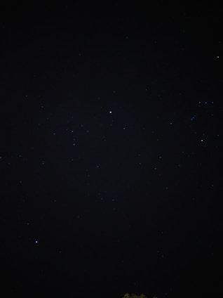 A dark, star-studded night sky filled with small, distant stars. The vastness and mystery of space are evident, with pinpricks of light scattered across the darkness.