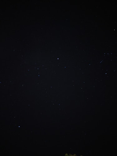 A dark, star-studded night sky filled with small, distant stars. The vastness and mystery of space are evident, with pinpricks of light scattered across the darkness.