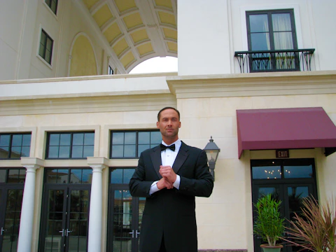 A poised young man in a tuxedo representing Mister Colombia on stage.