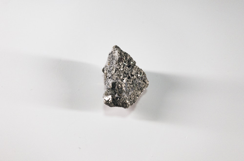 pietra nera e grigia su superficie bianca