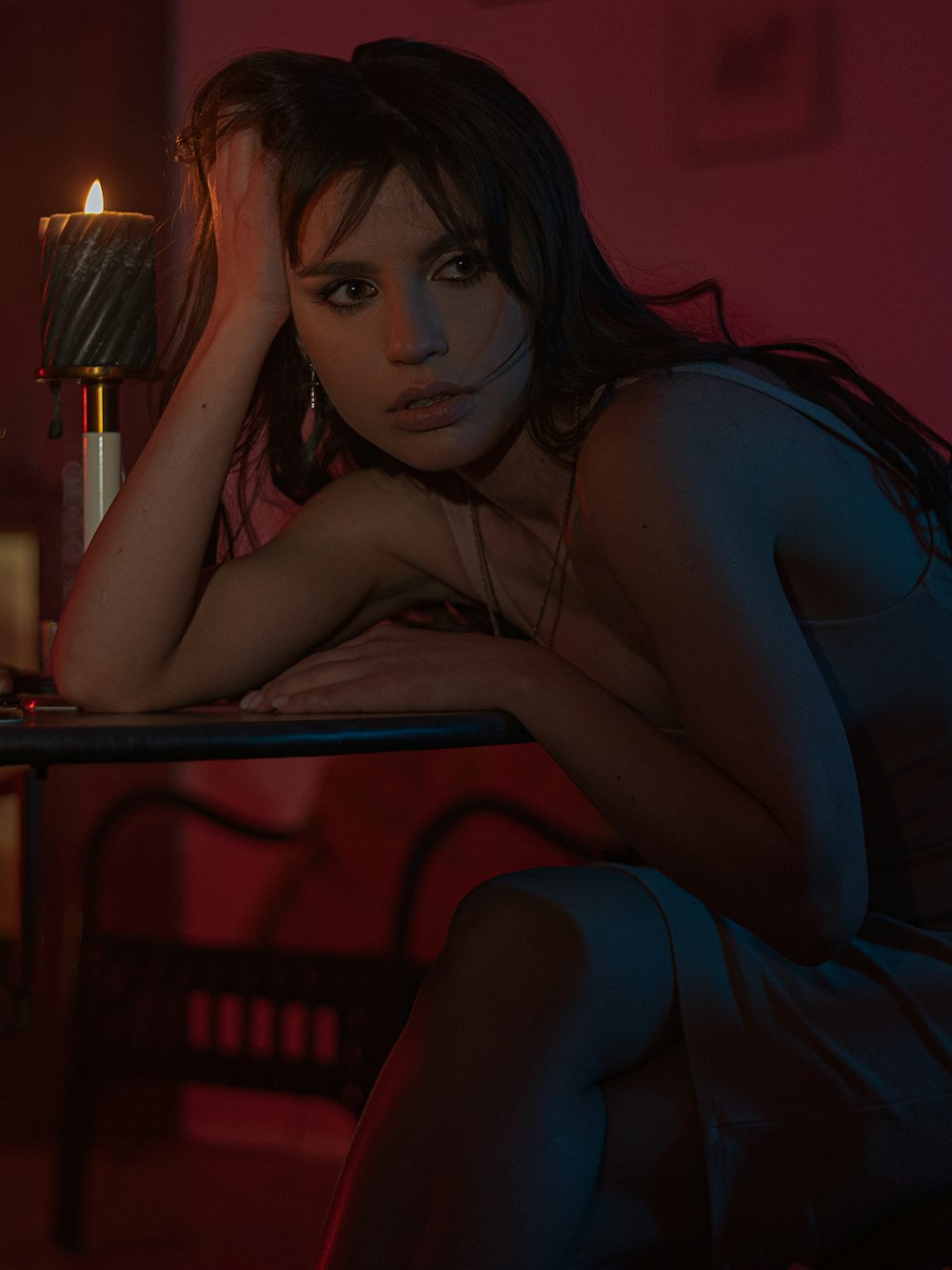 woman in blue sleeveless dress sitting on red chair