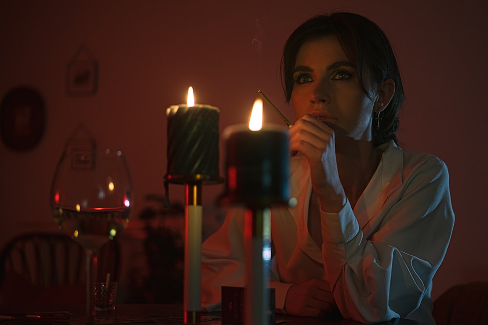 woman in white long sleeve shirt holding lighted candle