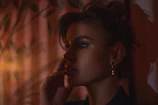 Lifestyle image of a woman wearing subtle earrings in a sunlit modern room.