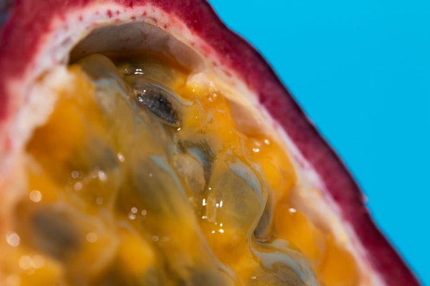 Close-up of vibrant frozen fruit pulps in elegant black and gold packaging.