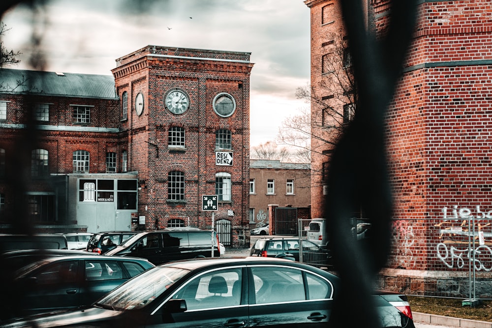 cars parked in front of brown concrete building during daytime