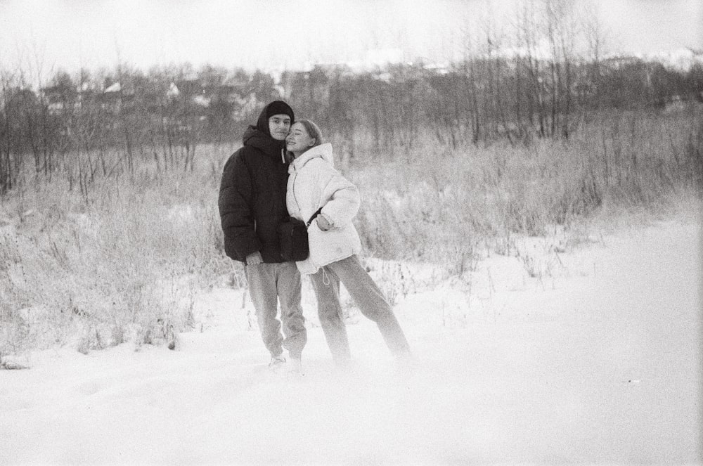 man and woman standing on snow covered ground