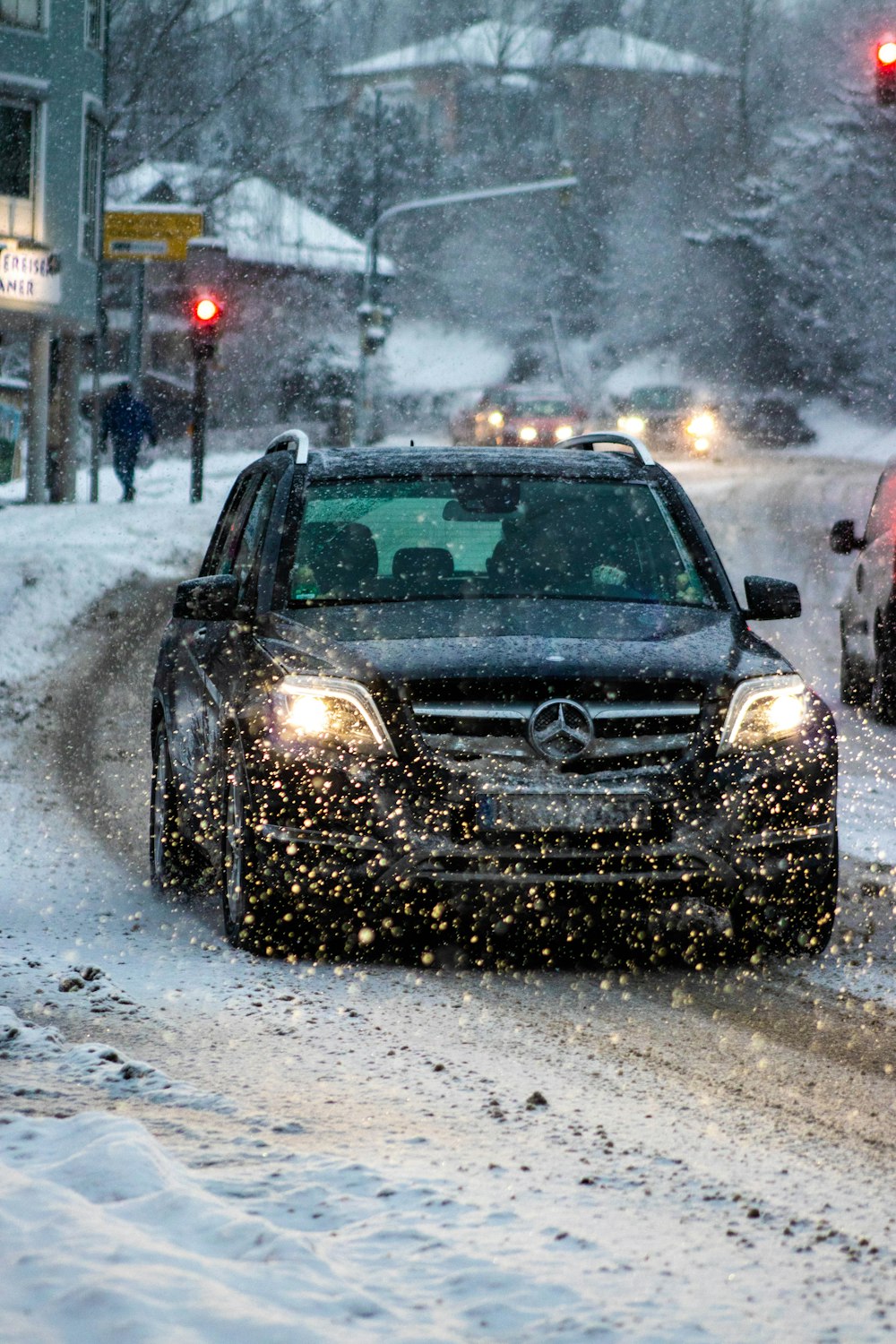 auto nera sulla strada coperta di neve durante il giorno
