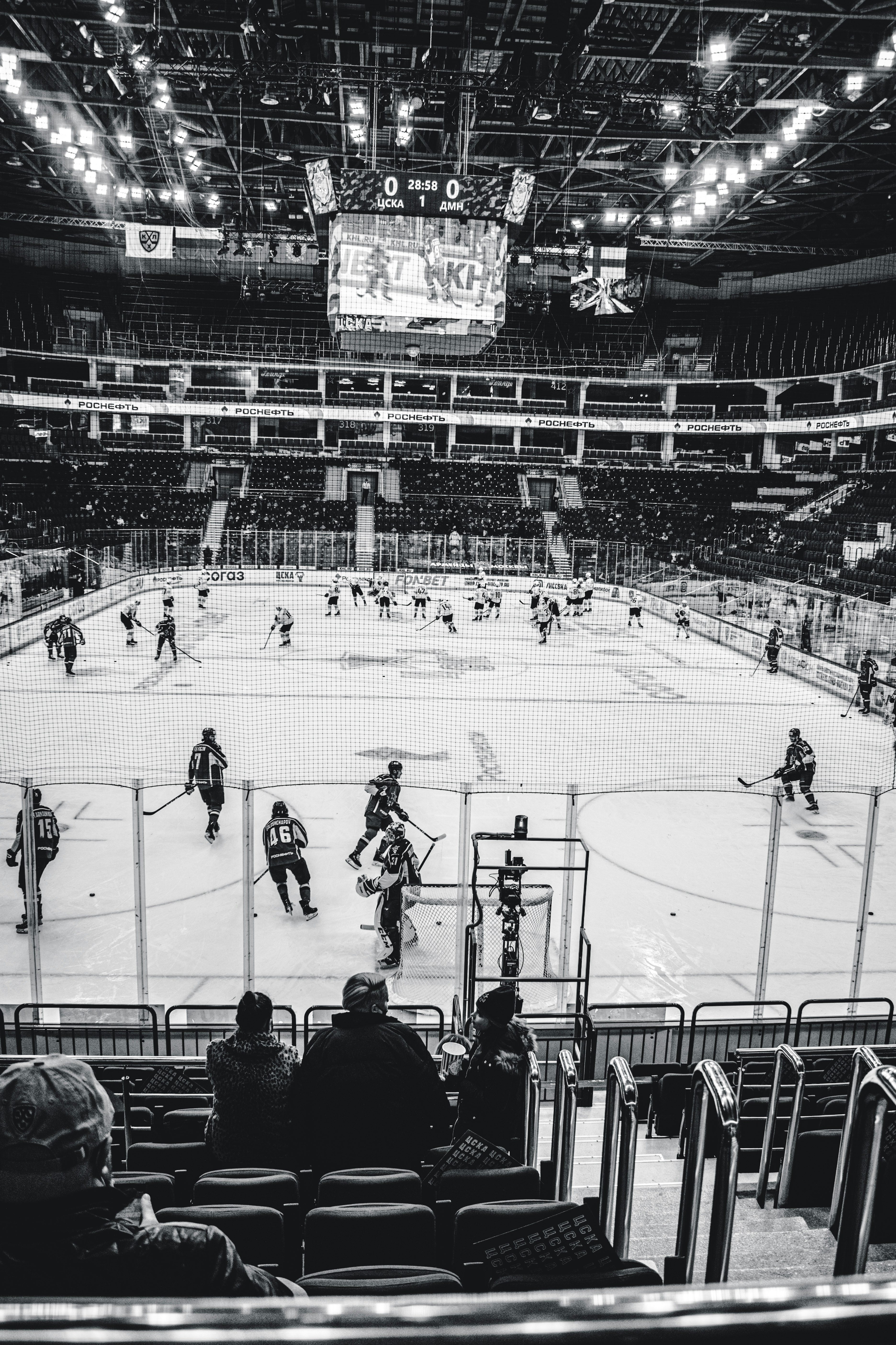 grayscale photo of people playing ice hockey