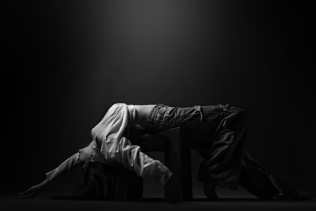 person in white pants lying on bed