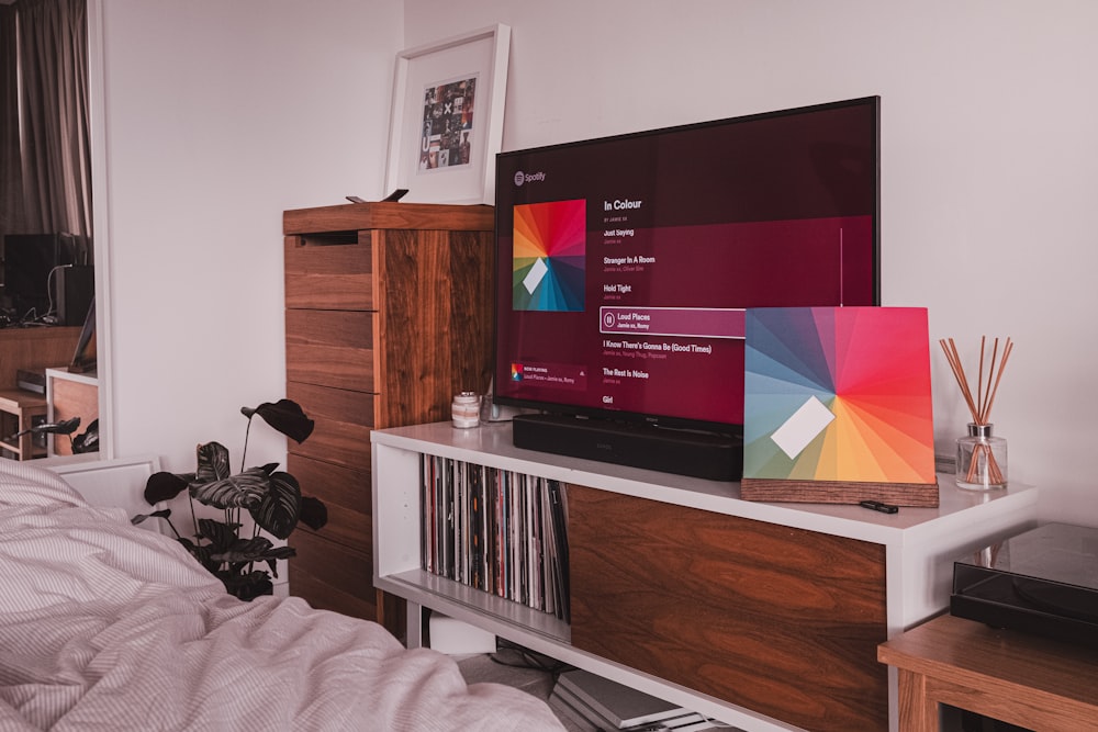 TV a schermo piatto nero su porta tv in legno marrone