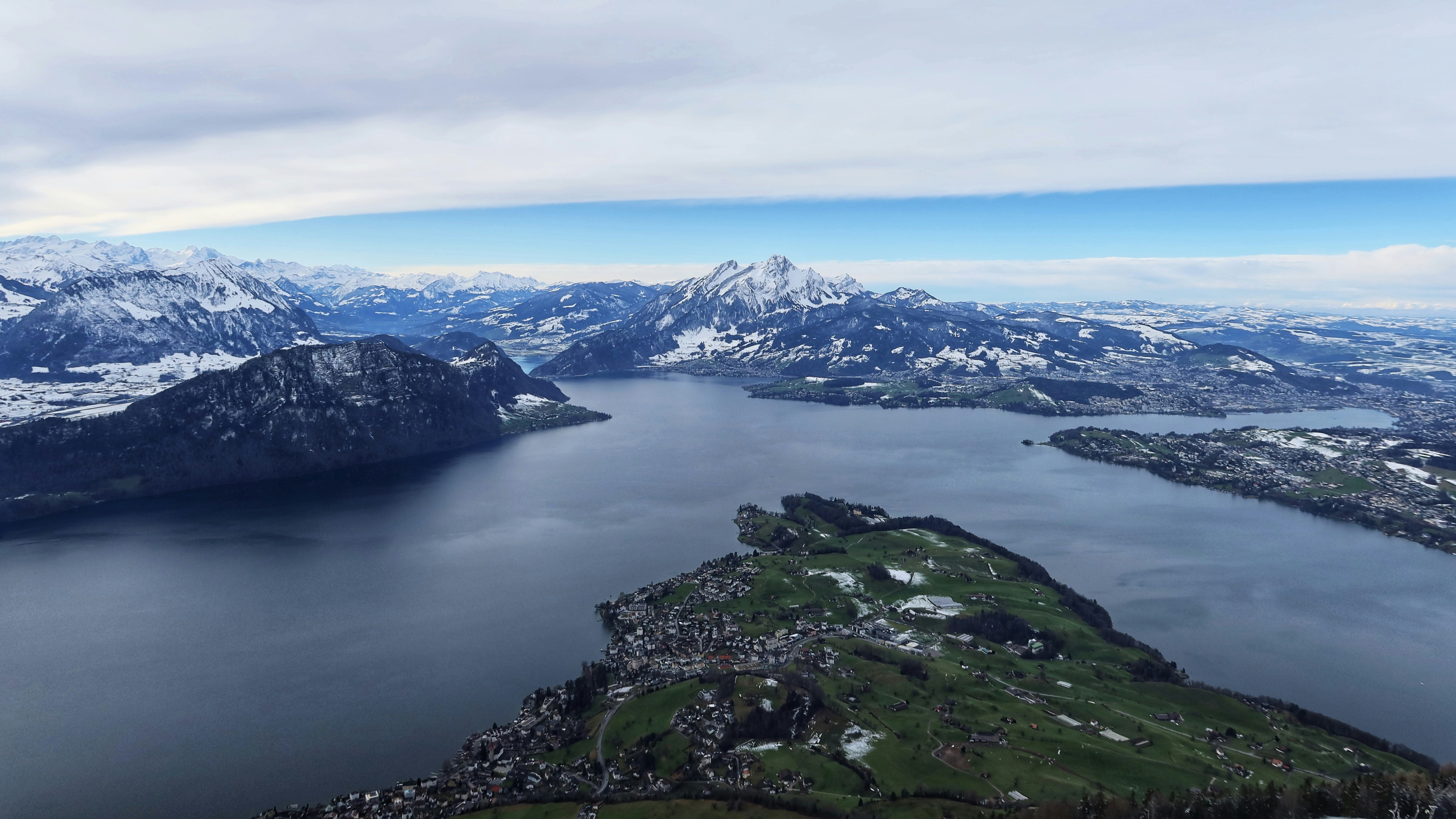 green grass covered mountain near body of water during daytime