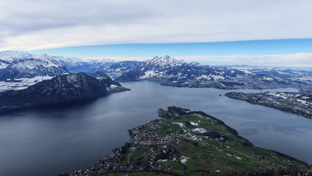 green grass covered mountain near body of water during daytime