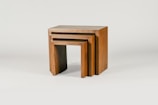 A set of small wooden side tables with smooth edges and natural finish.