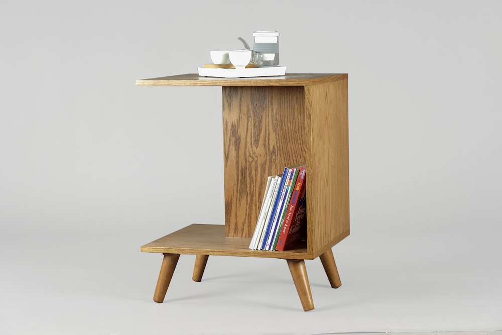mesa de madeira marrom com livros e canecas