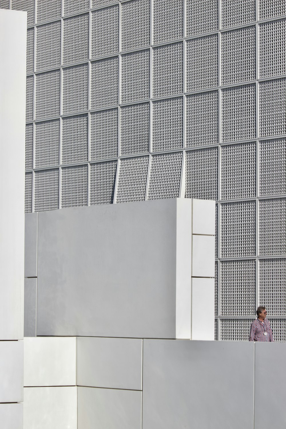 woman in pink long sleeve shirt standing beside white wall