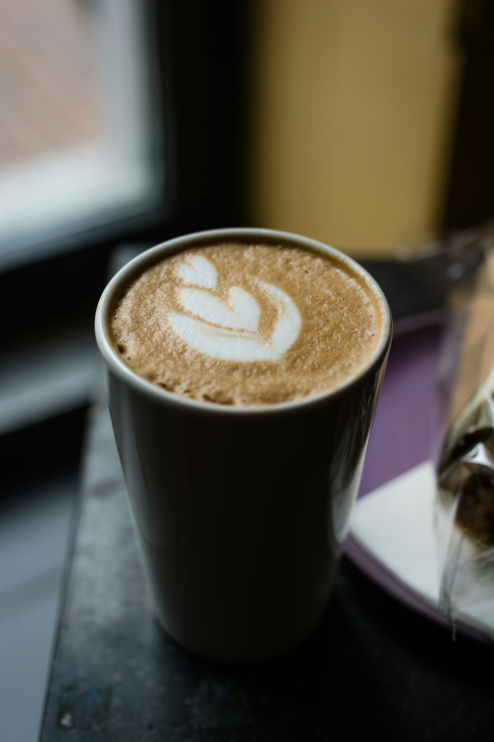 brown and white coffee in black ceramic mug