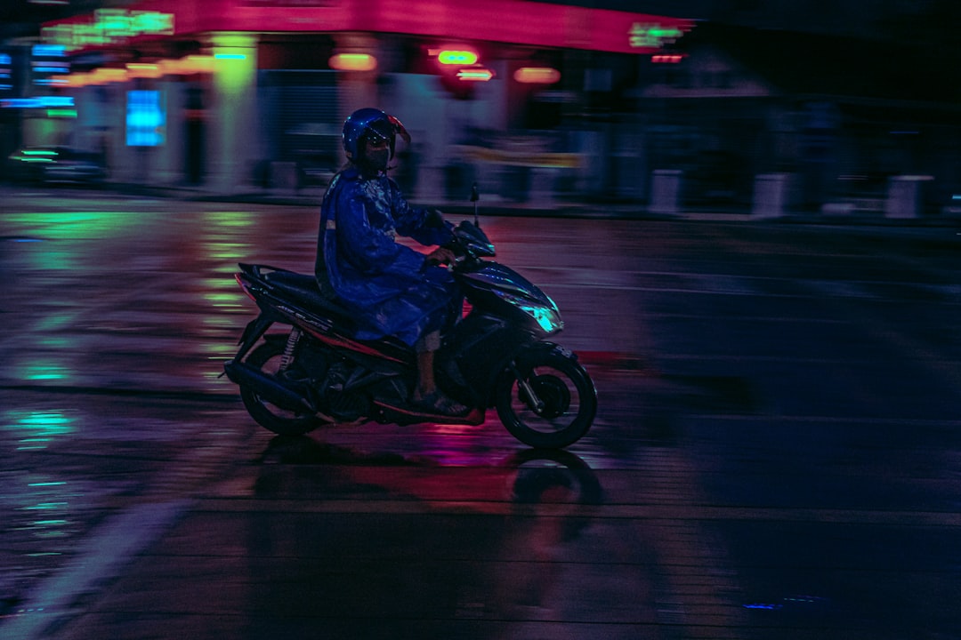 man in black jacket riding black motorcycle on road during night time