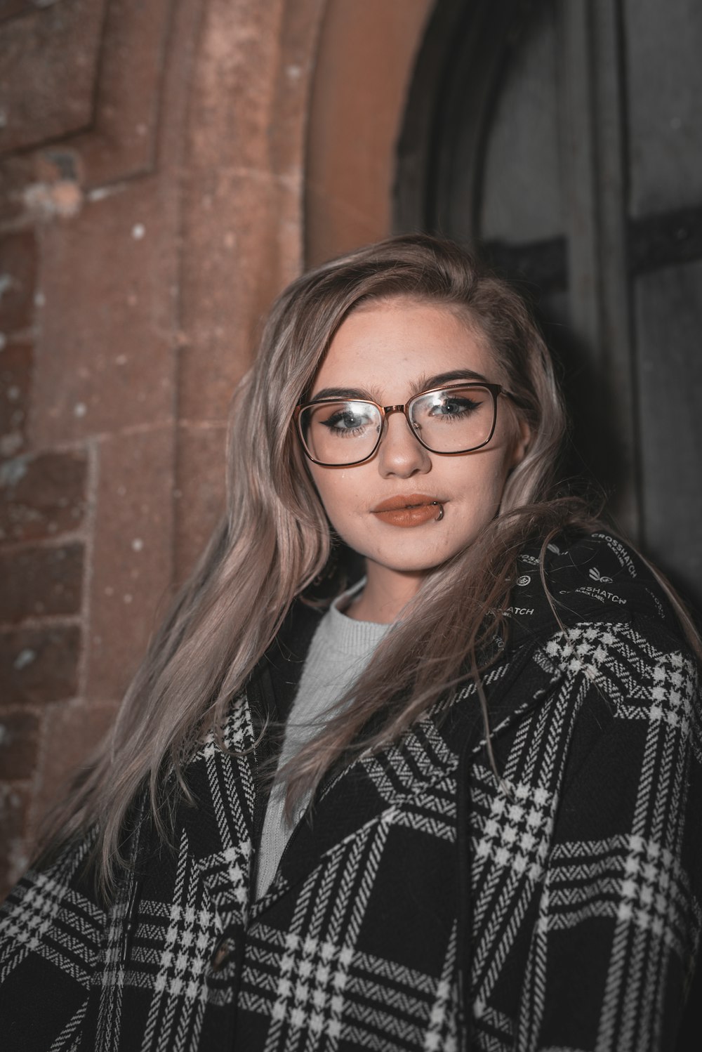 woman in black and white coat wearing black framed eyeglasses