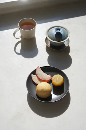 A serene morning scene with a cup of herbal tea beside pranaluz ayurveda products bathed in soft sunlight.