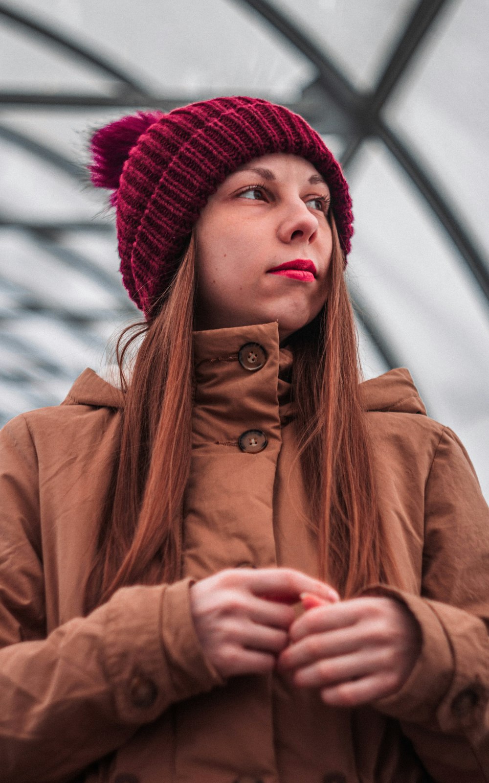 woman in brown coat and red knit cap