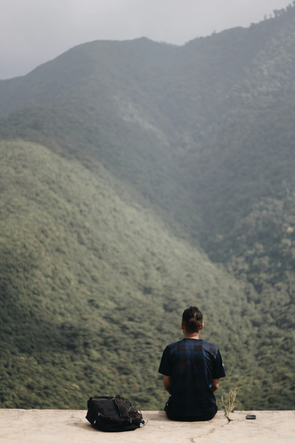 man in red and blue jacket standing on mountain during daytime