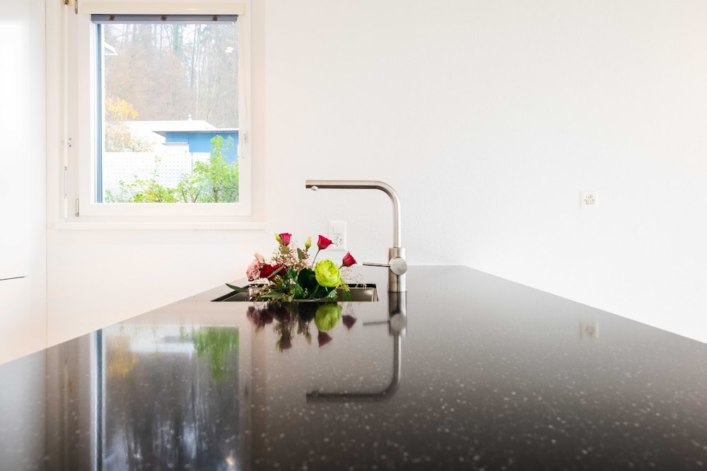 red and white flowers in clear glass vase on table