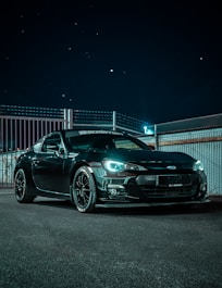 black bmw m 3 coupe parked on a parking lot during night time