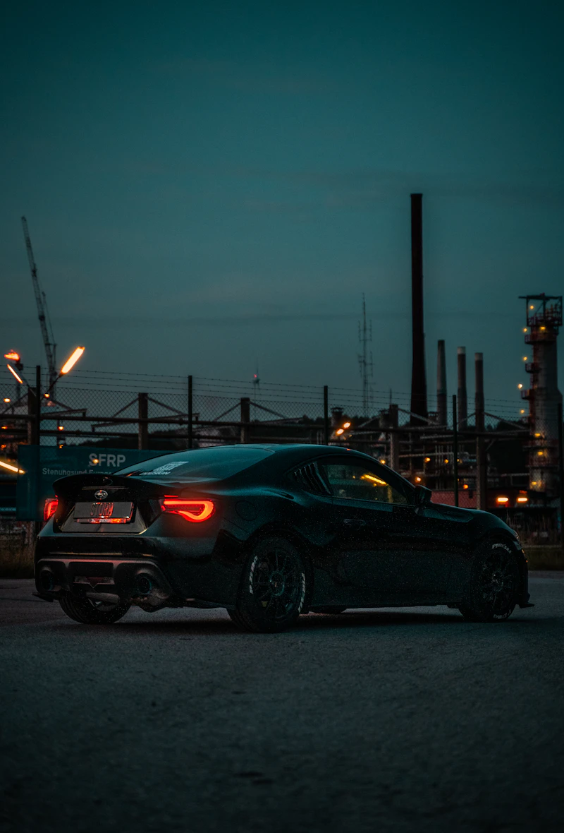Black sedan driving through the city at night