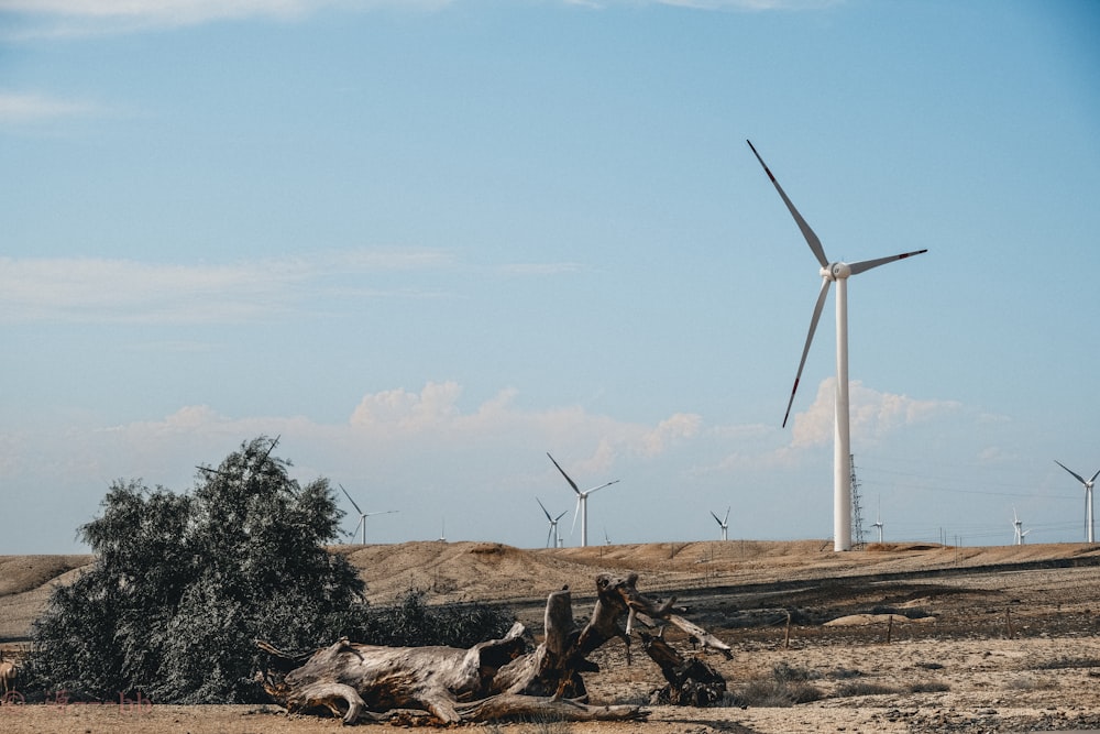 white wind turbine on brown field during daytime