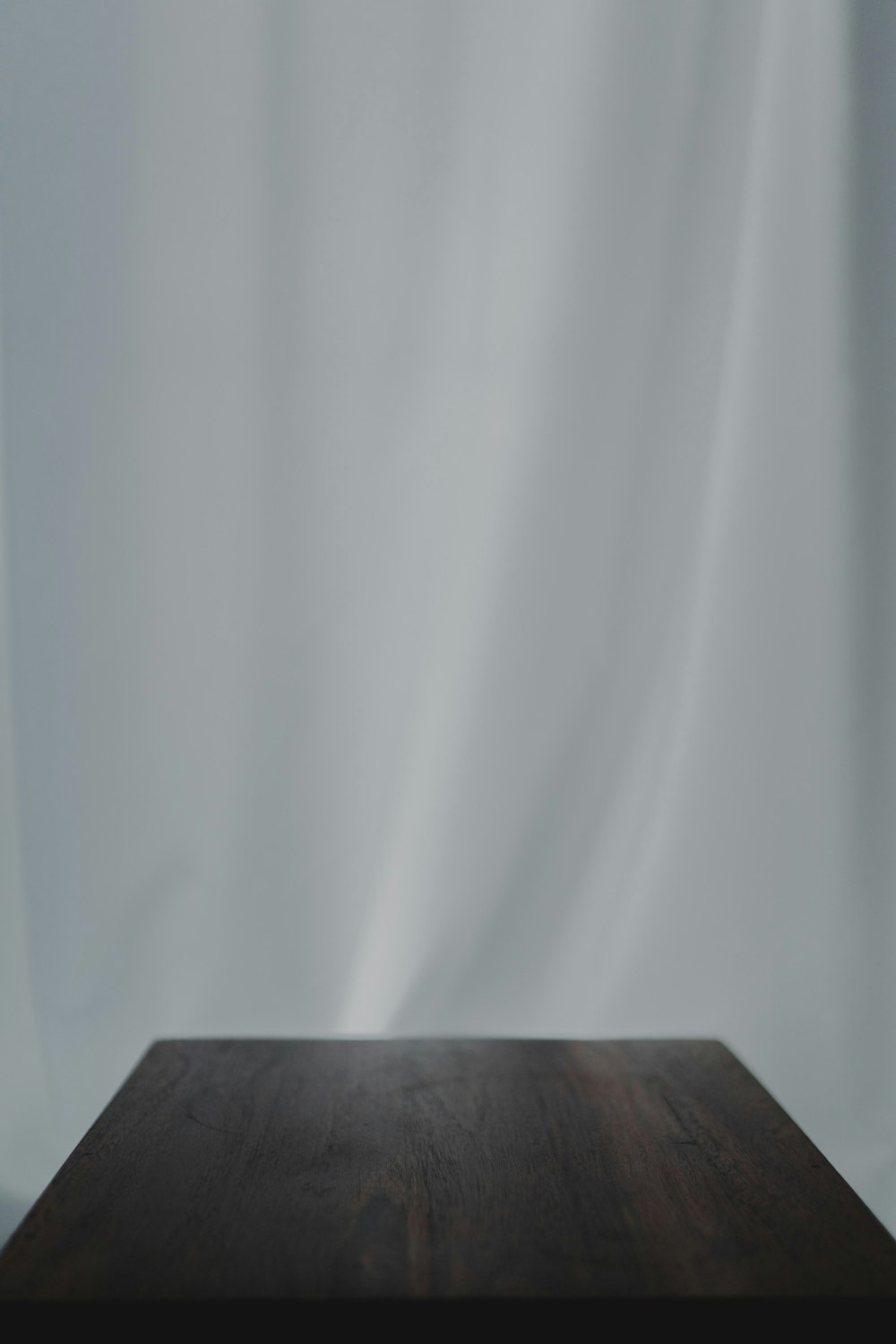 Tessuto bianco vicino al tavolo in legno marrone