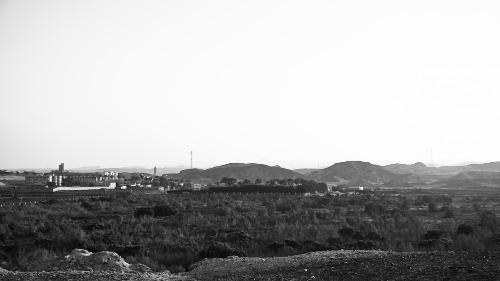 grayscale photo of city buildings and mountains