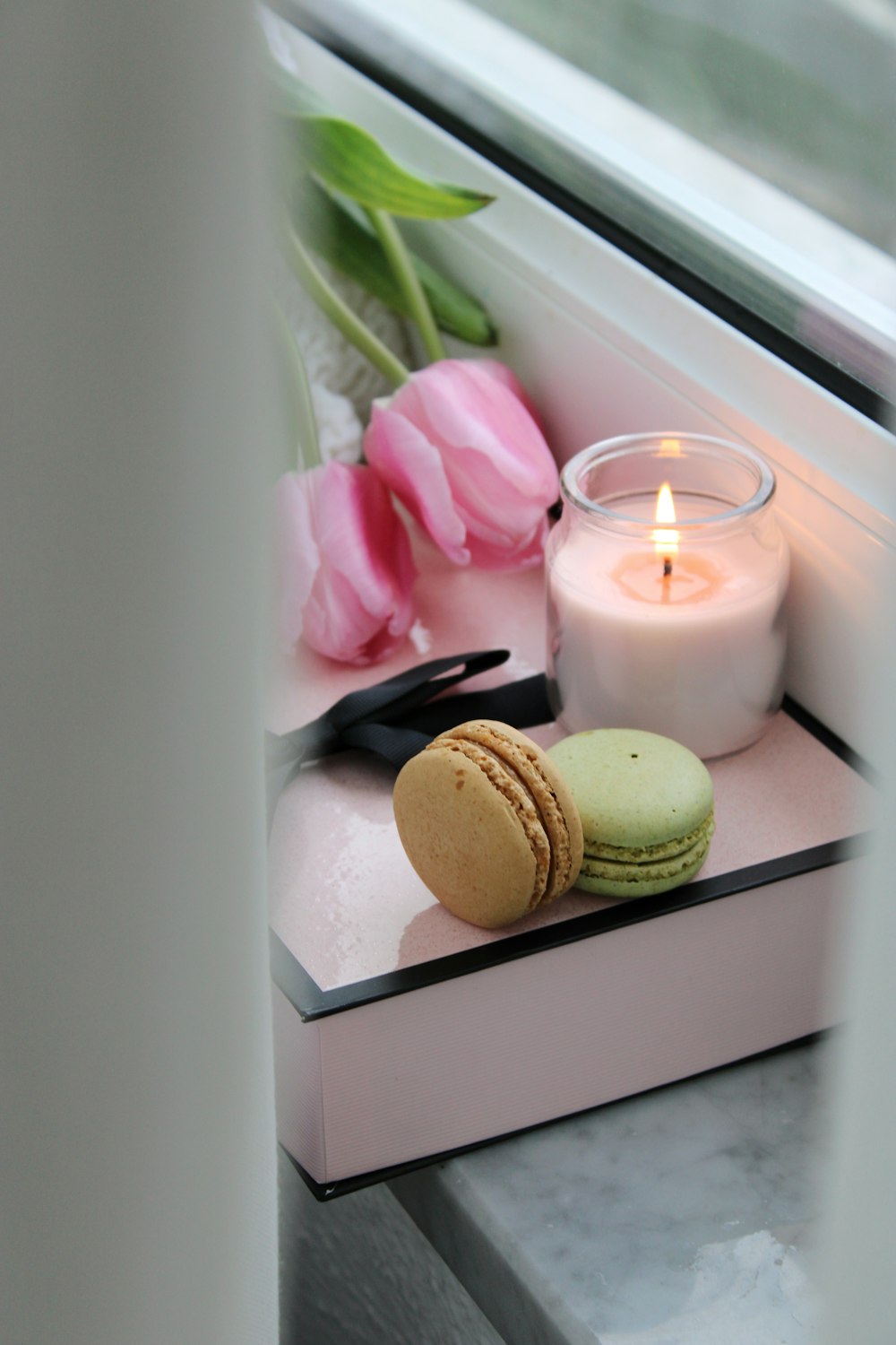 white and pink candles on white wooden shelf