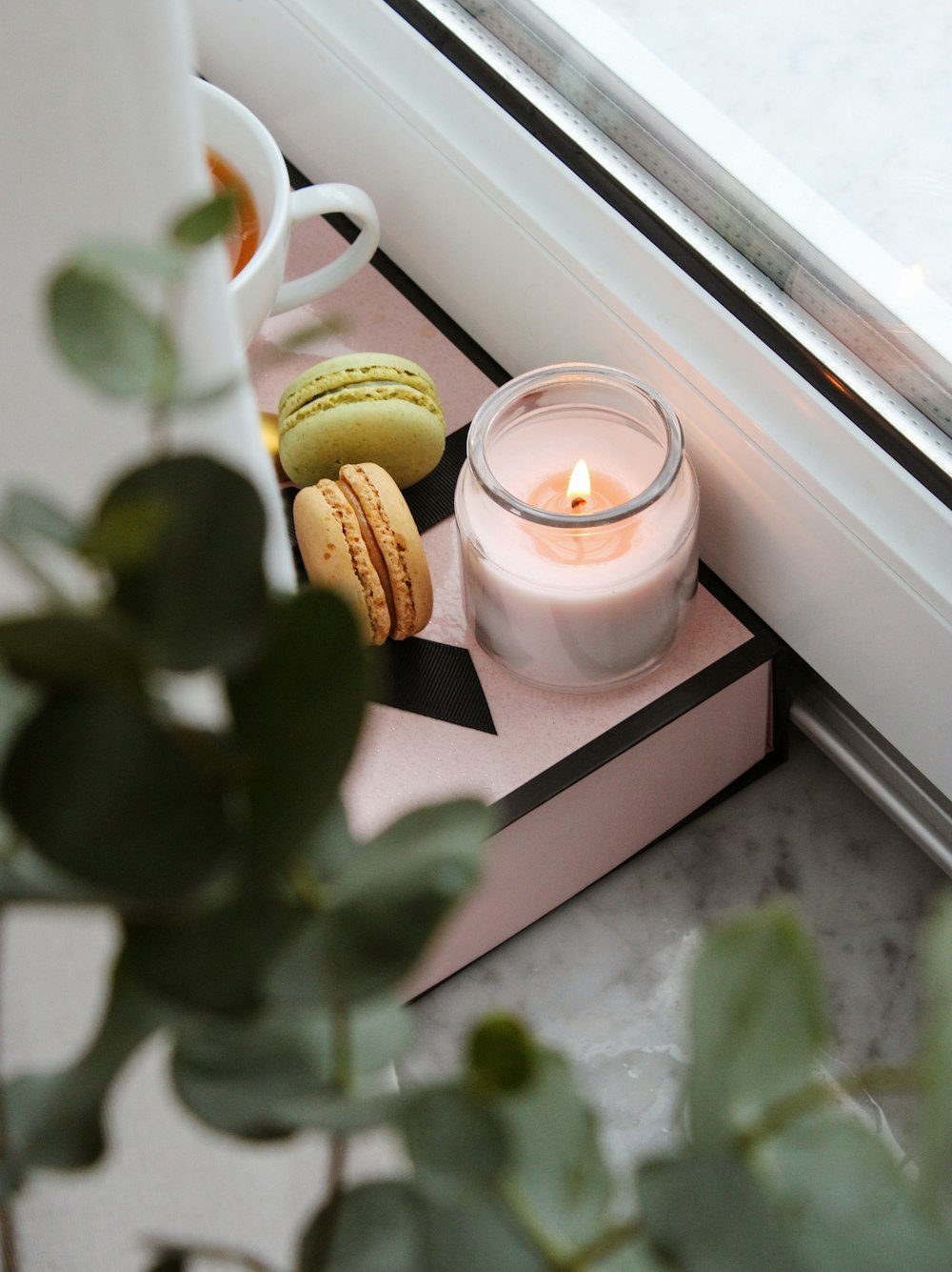 white candle in clear glass holder