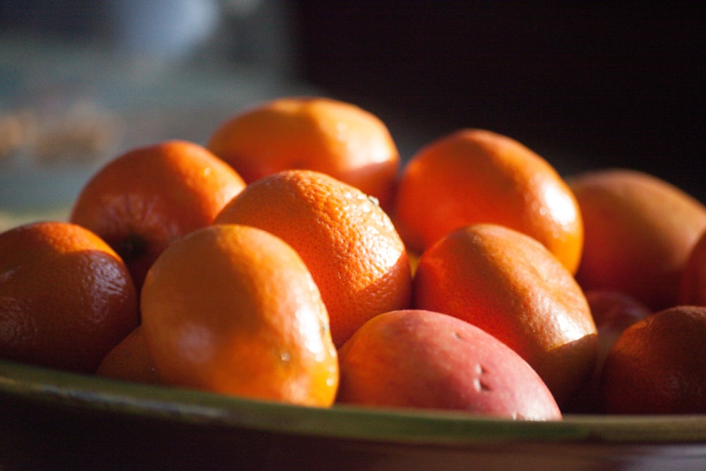 orange fruits on green ceramic bowl
