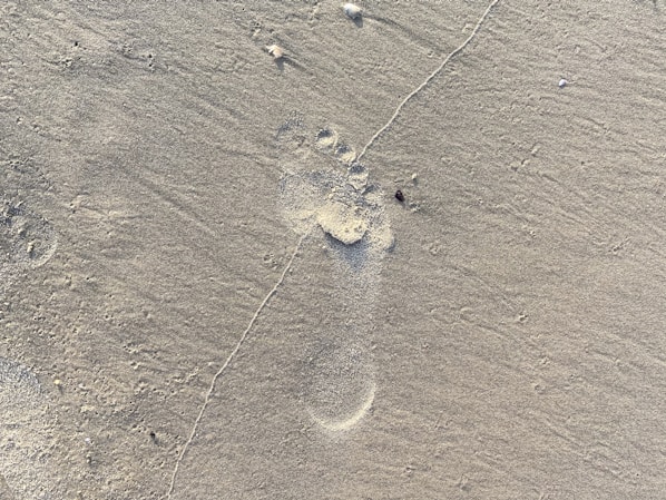 Close-up of a person stepping into a foam footprint kit at home, capturing the unique shape of their foot.