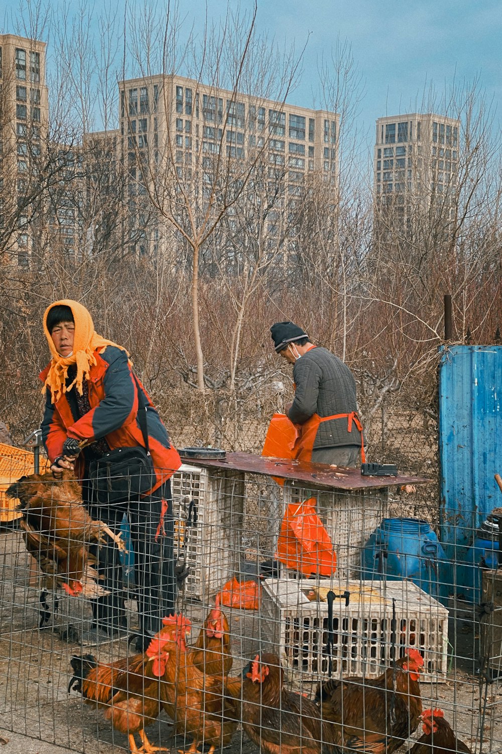 man in black jacket and orange pants holding brown short coated dog